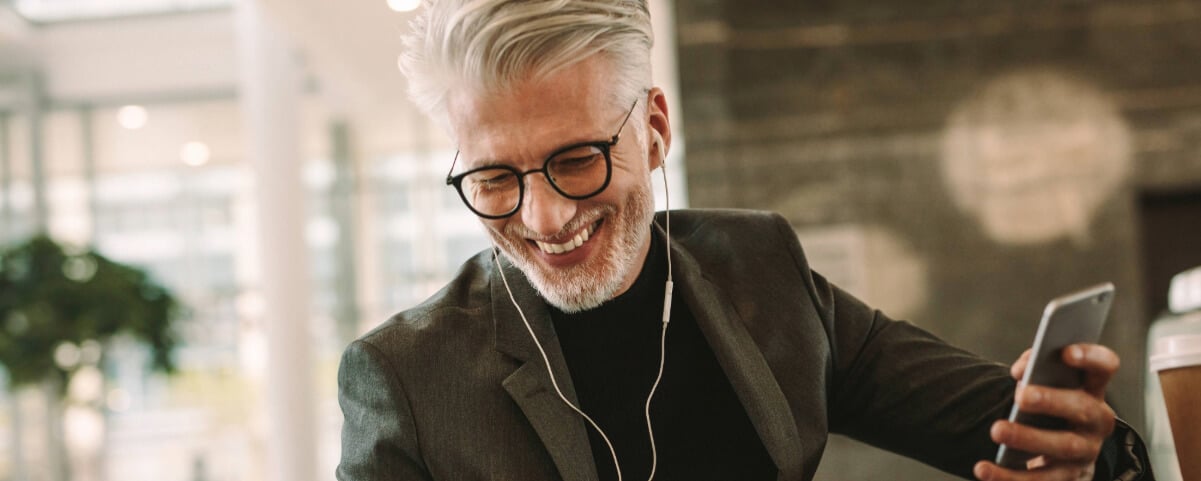 Smiling businessman in earphones and cellphone