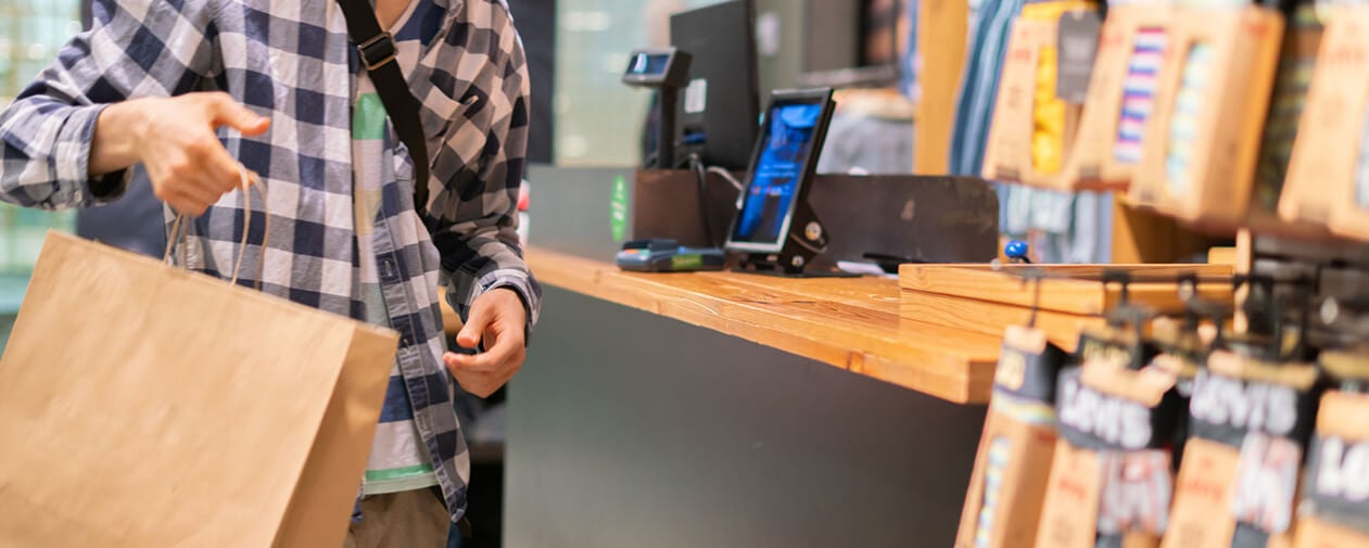 young man making a purchase and paying in the store