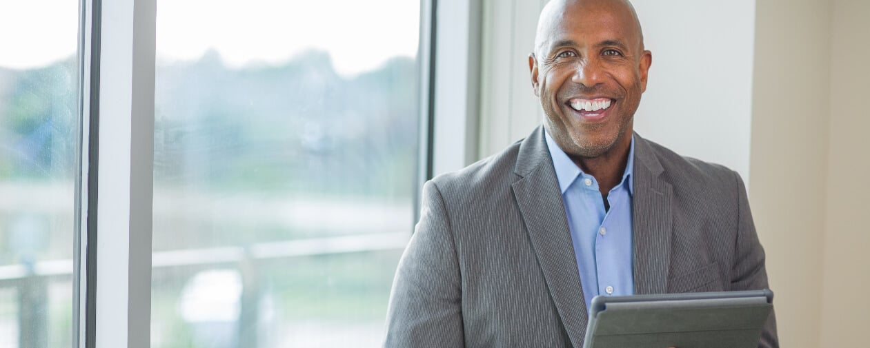 Confident, top-performing sales person smiling in office