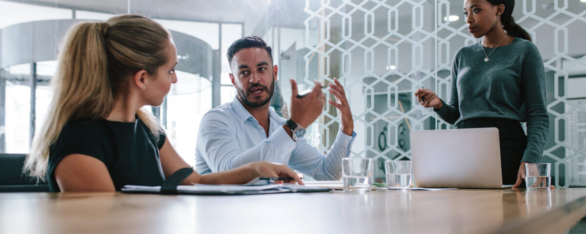 Young man sharing his views with coworkers in boardroom during business meeting.