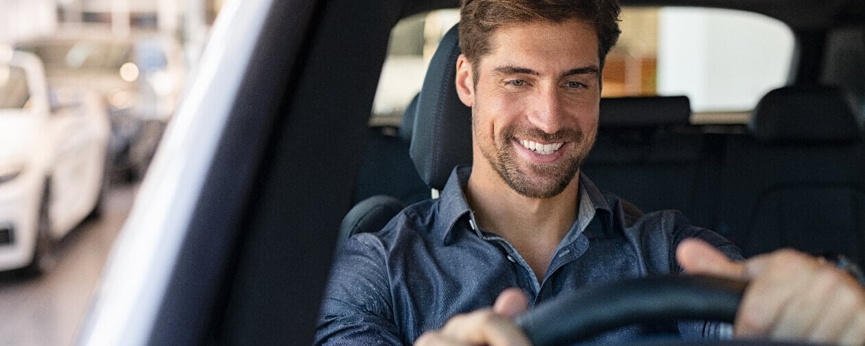 Happy new car customer sitting in driver's seat