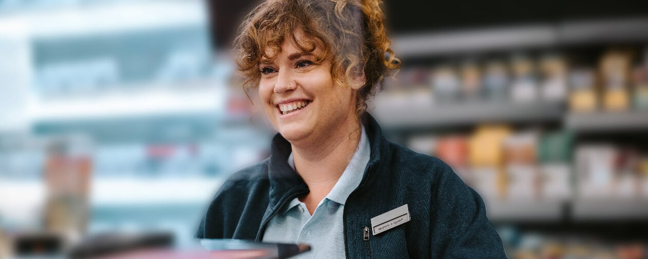A smiling retail representative helping a customer