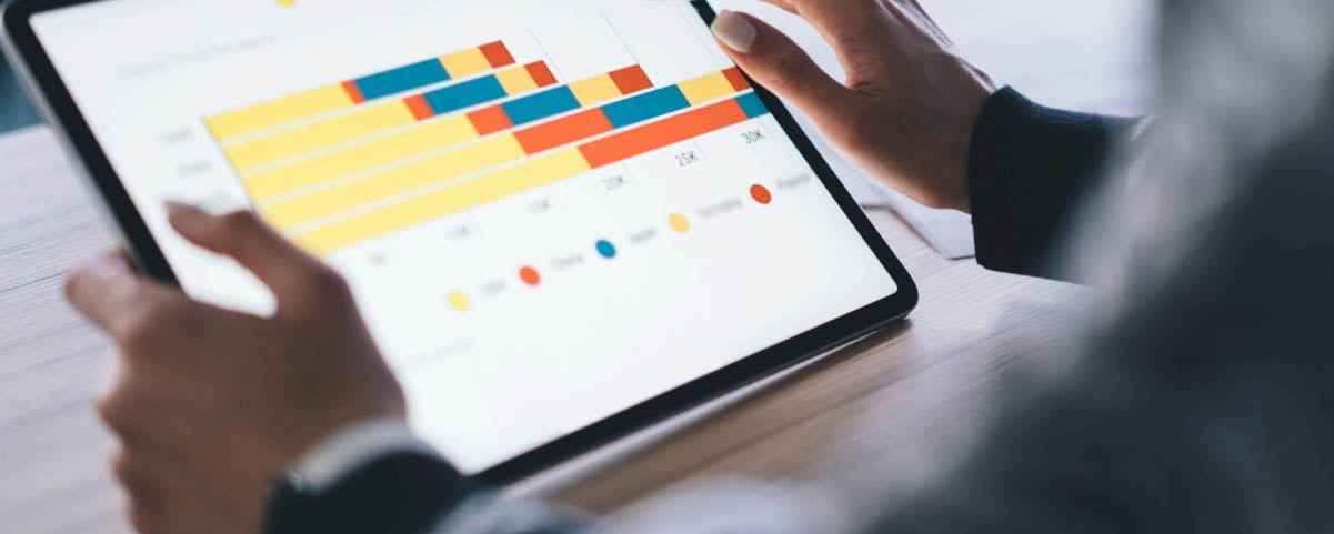 Woman using tablet with bright colorful bar chart in office