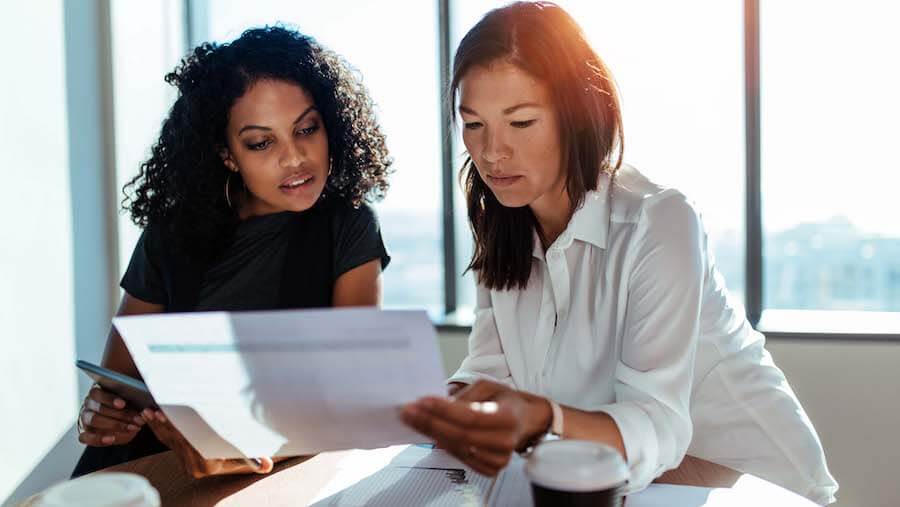 Two colleagues carefully reviewing information