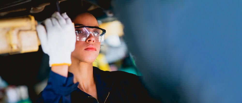 Mechanic woman working on a vehicle in a car service